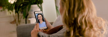 En person sedd bakifrån som tittar på Alltid öppet-appen i sin mobil